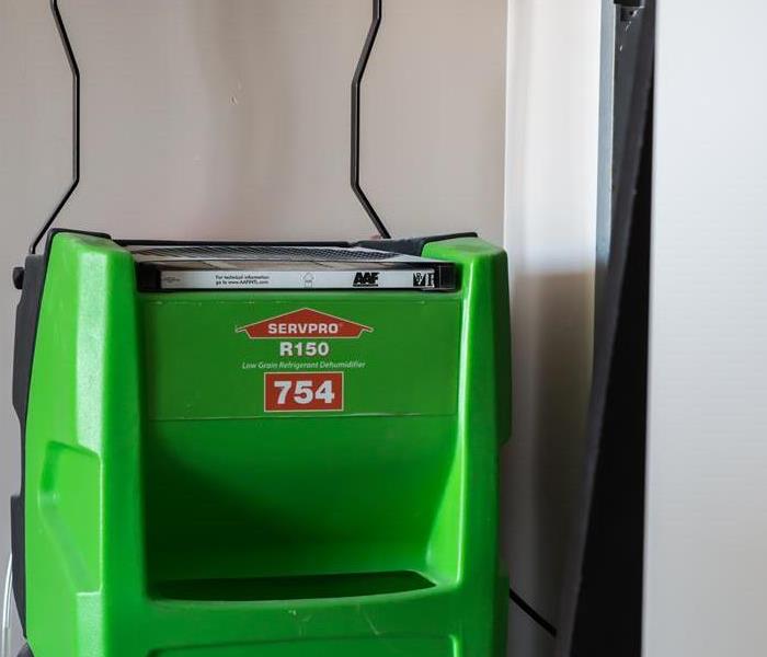 Our dehumidifier with the SERVPRO green and iconic logo sits in a corner waiting to save the day from mold and water damage!