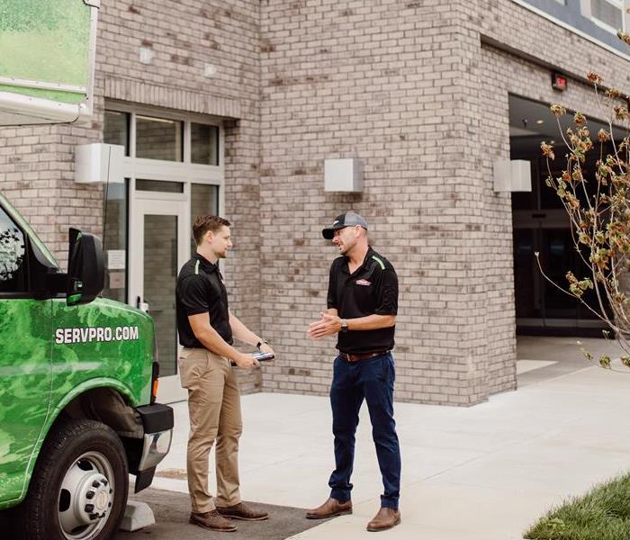 The SERVPRO team members in front of a building to carry out commercial restoration services!